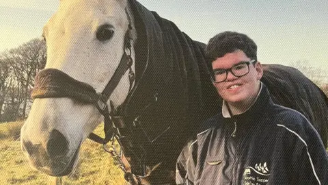 Family photo of Fraser with a horse outside in a field
