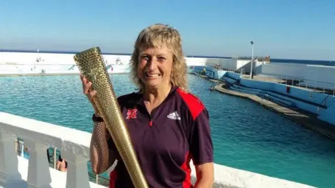 Yvonne Turner Yvonne Turner holding the Olympic flame in 2012. 