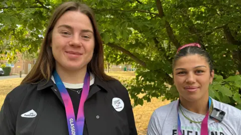BBC/Zac Sherratt two female gold medallists pose with their medals for the camera