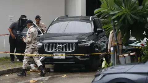 Reuters Police officers inspect a black car surrounded by police tape