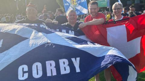 Two Scotland fans and two Swiss fans with flags