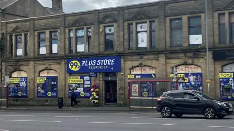 A two-storey building with large yellow and blue signage advertising homeware.
