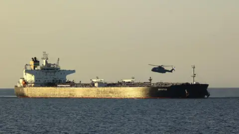 UK MOD Crown copyright A helicopter hovers over the CMR Smyrtos in the sea 