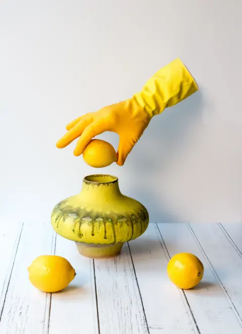 Tom Plucinski A yellowish  gloved hand, suspended successful  the aerial  without being attached to a body, holds a citrus  supra  a yellowish  vase. Two much  lemons beryllium   connected  a array  successful  beforehand   of the vase.