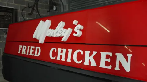 Large red sign with Morley's fried chicken written in white upon it