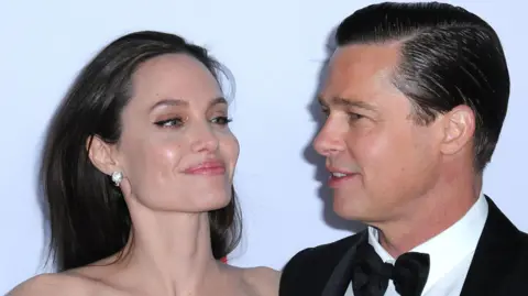 Getty Images Angelina Jolie dan Brad Pitt saling tersenyum di karpet merah pada gala premier By the Sea di festival AFI 2015 di Los Angeles