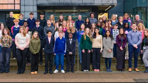 Wiltshire Council A large group of about 30 young people standing for an official photo on the steps of a council building