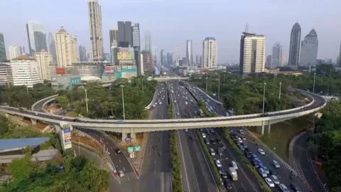 Jakarta Cityscape, četri satiksmes ceļi, fonā ir daudz debesskrāpju.