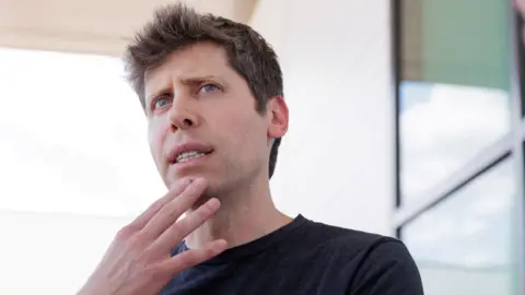 OpenAI chief Sam Altman on an outdoor patio looking pensive and touching his hand to his chin.