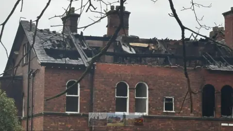 BBC The partially collapsed roof and burnt out parts of the former red brick convent