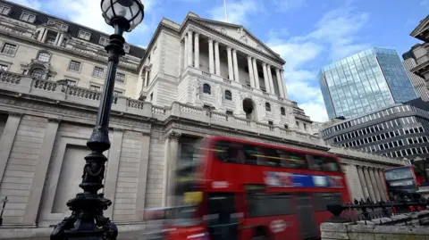 Reuters View of the front of the Bank of England building with a red London bus passing by