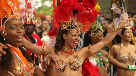 Getty Images Smiling and dancing carnival performers with colourful outfits