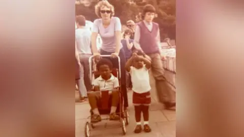 Margo Clarke A photograph from the 1970s shows the family walking along a prom, with six year old Adrian in his younger brother's pushchair, while his three-year-old brother walks alongside.