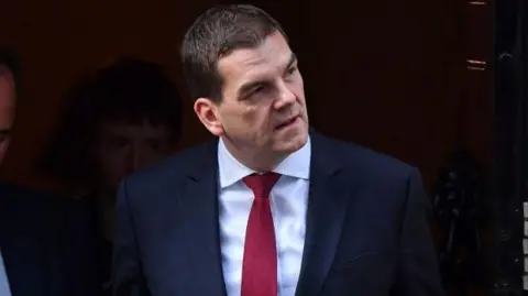 Getty Images Oliver Robbins turns away from journalists upon leaving 10 Downing Street dressed in a suit during his tenure as Brexit negotiator in 2019