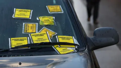 PA Media A Land Rover with several Penalty Charge Notices on its windscreen