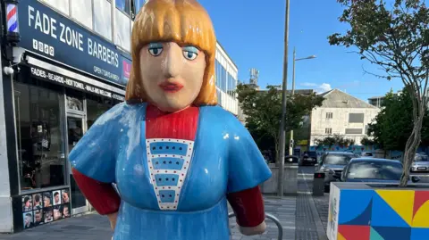 Sculpture of a large woman wearing a blue dress 