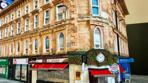A cardboard model of Union Corner. It is a Victorian Building with colourful shop fronts on the ground floor.