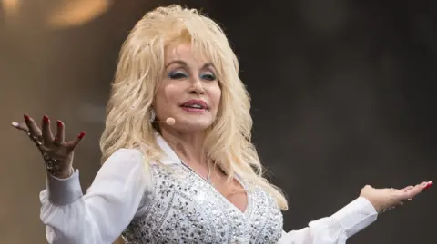 Dolly Parton in a white jewelled outfit