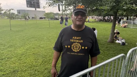 Melvin Graves wears a T shirt saying 'Army veteran - still serving America'