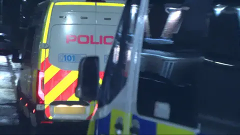 Two police vans in a dark street