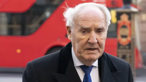 PA Sir Frederick Barclay. An old white man in a shirt and tie walks with purpose in central London.