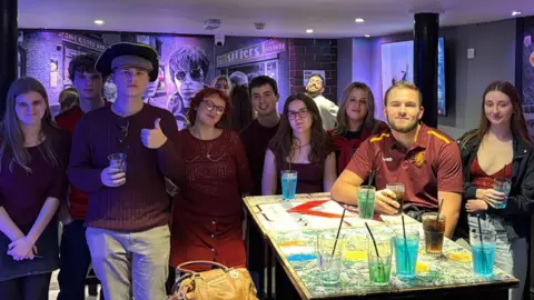 UoY Northern Society A group of students in a bar, all wearing red.