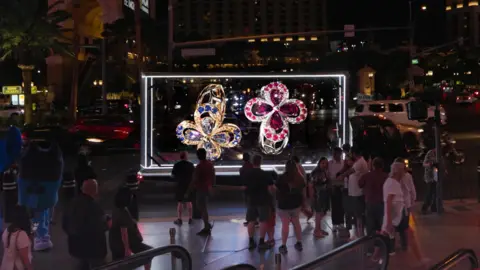 Hypervsn An advertising truck is parked in a city street with brightly coloured holograms being shown to members of the public who are standing around it