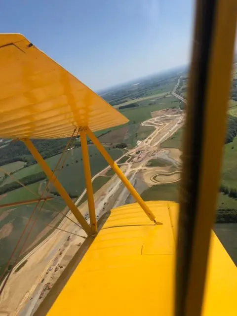 Martyn Carrington An aerial view of the construction of a new road seen from the yellow biplane.