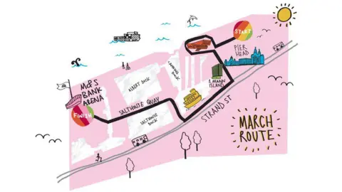 Sahir Am illustrated pink map showing a route starting at Liverpool's Pier Head. There is a rainbow circle with white writing reading "Start". A black line details the route passing 1 Mann Island along Strand Street, along Salthouse Quay at the Albert Dock to the M&S Bank Arena where there is a rainbow circle with white writing reading "Finish".