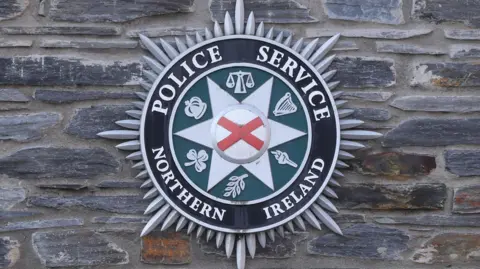 PSNI Crest on a a stone wall