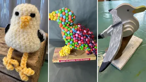 Artworks Art4All CIC A composite of three model seagulls. The left most is a small design made of felt. The middle is made of colourful skittles. On the right, the seagull is made of varying sizes of wood.