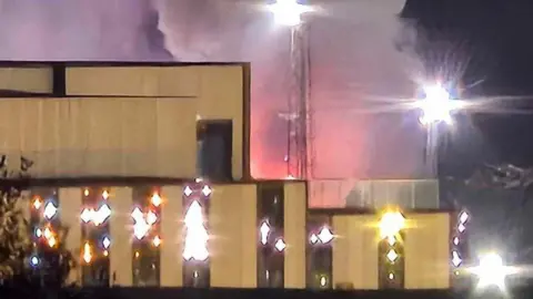 Fife Jammers red plumes of smoke appearing from behind a building