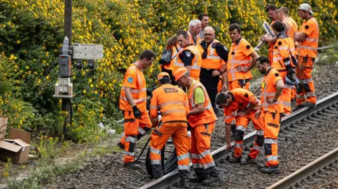 echnicians of French railway company SNCF work to reconnect railway cables at the Mont-de-Terre train station in Lille, northern France on June 25, 2025. 