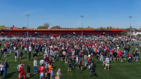 Jay Wrighte Fans celebrating on a football pitch