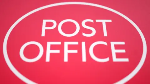 A big red Post Office sign, with a white circle round it