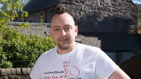 Kevin Newell Kevin Newell standing outside wearing a white T-shirt