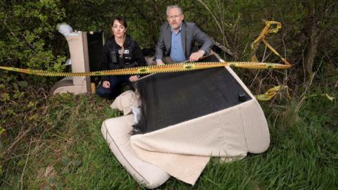 Cllr Mark Wilkes, Durham County Council’s Cabinet member for neighbourhoods and climate change, is pictured with neighbourhood warden Claire Liddle with a sofa that has been fly tipped in the Esh area