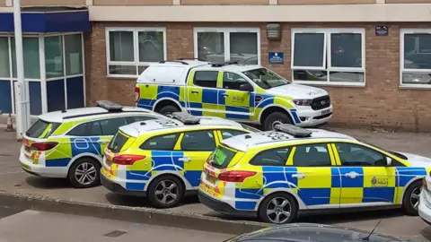 Four police vehicles in front of a police station