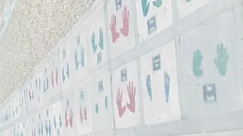 Maidstone Borough Council Multi-coloured handprints on a wall.