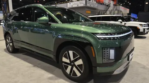 A dark metallic green Hyundai Ioniq 9 electric vehicle on display at the Chicago Auto Show.