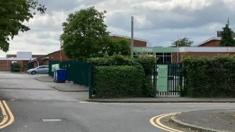 A Google Maps picture of Oakbank School, with its reception visible through a gate.