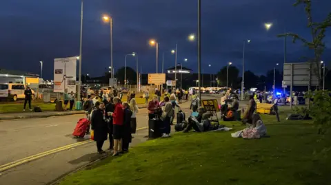 Stranded travellers waiting outside the airport