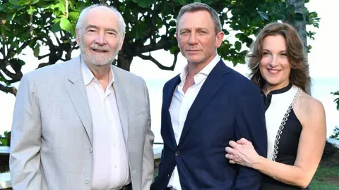 Getty Images Daniel Craig standing between Michael G Wilson and Barbara Broccoli