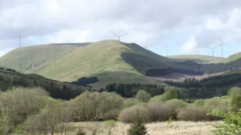 A visualisation of how the Lorg wind farm might look with turbines visible from behind rolling hills