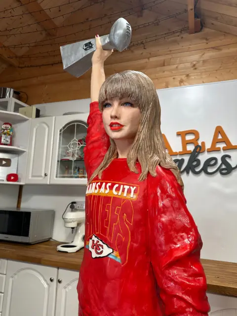 Lara Mason The Taylor Swift cake holding a Super Bowl trophy in the air