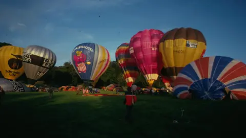 Richard Cardy Hot air balloons inflated but still tethered resting near the ground