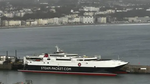 The Manannan, a sleek catamaran, it is moored on Douglas harbour, you can see Douglas prom in the background, on a dull day.