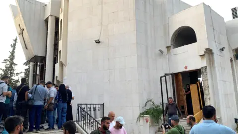 Reuters People inspect damage following a suicide bomb attack at the Mar Elias Church in Dweila, a suburb of Damascus, Syria (22 June 2025)