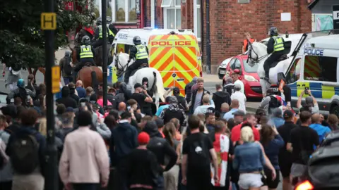 PA Media Mass protests and police on horses and police vans