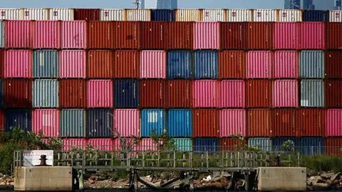 Shipping containers piled high in a variety of colours
